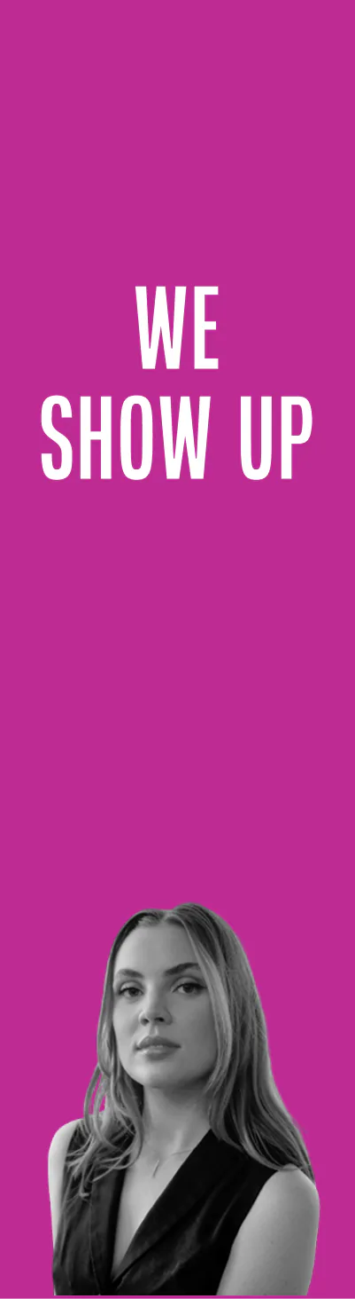 Portrait of a serious young woman with long hair wearing a sleeveless black top, beneath bold white text reading 'WE SHOW UP' on a magenta background.